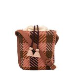 Front of artisan hand woven Betty Cylinder Crossbody in Moss Weave. It's a drawstring bag with peach tassels. The moss weave is an olive green and orange plaid. It has an adjustable leather strap.