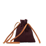 Back of the hand woven artisan Eloisa Small Crossbody in Season Sparkle. The back has a solid brown color and a leather strap.