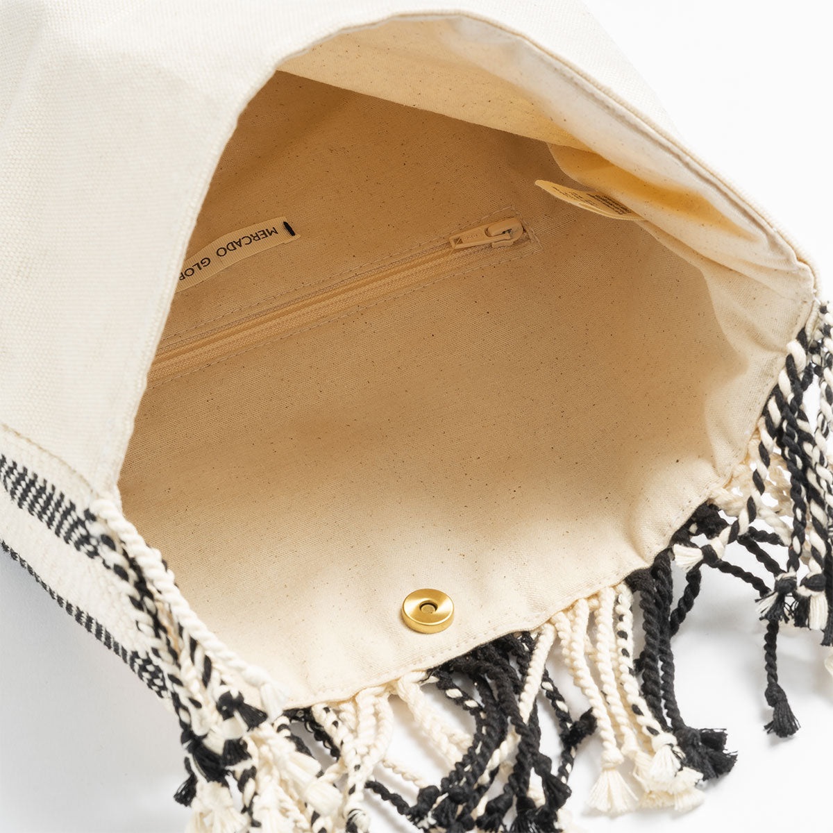 Inside view of the Margarita Clutch Tourmaline Basket weave. It has a beige lining and an interior pocket. It has a magnetic clasp.