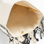 Inside view of the Margarita Clutch Tourmaline Basket weave. It has a beige lining and an interior pocket. It has a magnetic clasp.