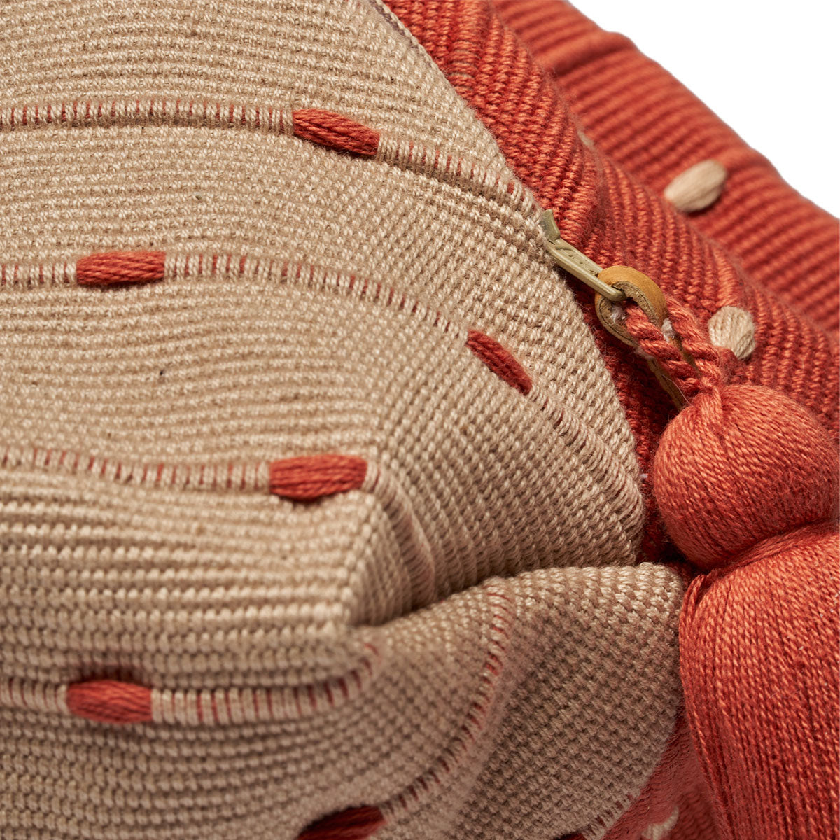 Dulce Wristlet in Desert Sands. A close up of the zipper detail with a leather pull and pink tassel.