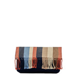 Front view of the Margarita Clutch in Blue Canyon. It has vertical orange, navy blue, light blue, beige, and tan stripes with fringe. It is folded over, revealing the pattern.