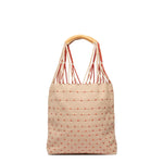 Back view of the Apolonia Tote in Desert Sands. It has a reverse pattern on the back, beige and pink dots. It has thread wrapped cord handles.