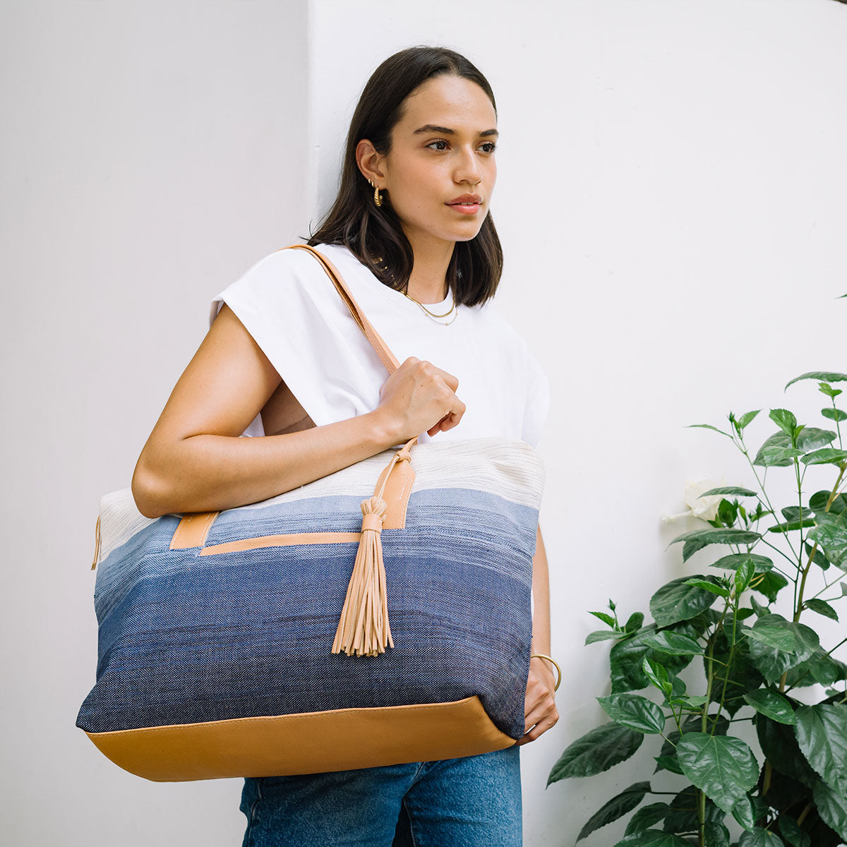 A model wears the Soledad Weekender in Ocean Breeze over her shoulder.
