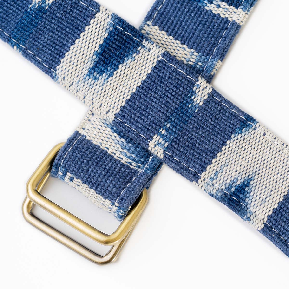 Zoomed-in details of the Celeste Belt in Atitlán Hills pattern, showing the belt buckle. It has vertical and chevron dark blue and white stripes.