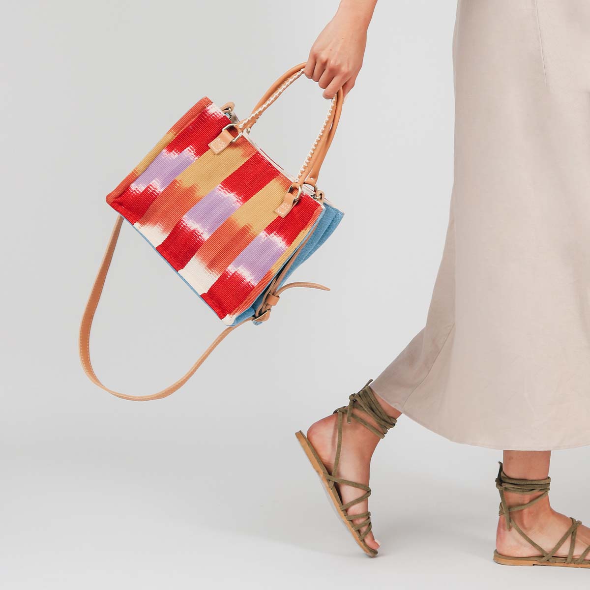 A model holds the hand woven artisan Mini Irma Tote in Raspberry Paleta.