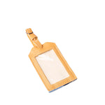 The front of the Ines Luggage Tag in 90s Denim. It has a leather adjustable strap, a plastic cover, and a leather case.