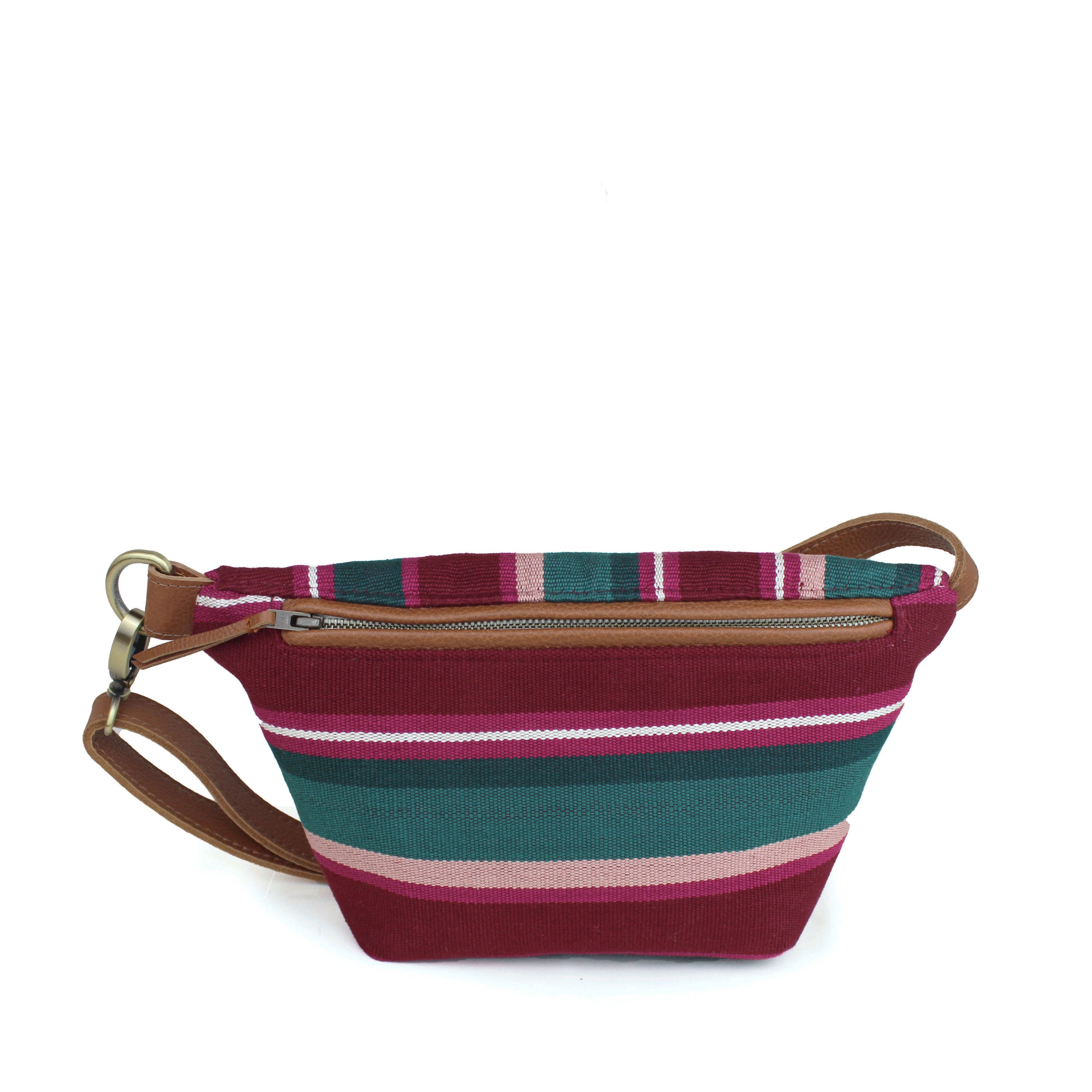 Front view of the Cruza Artisan Handwoven Ginger Sling. It has a maroon, pink, and phthalo green pattern. The front in vertical stripes and back in horizontal stripes. It has a leather waist strap, a leather zipper pull, and leather hem for the zipper.