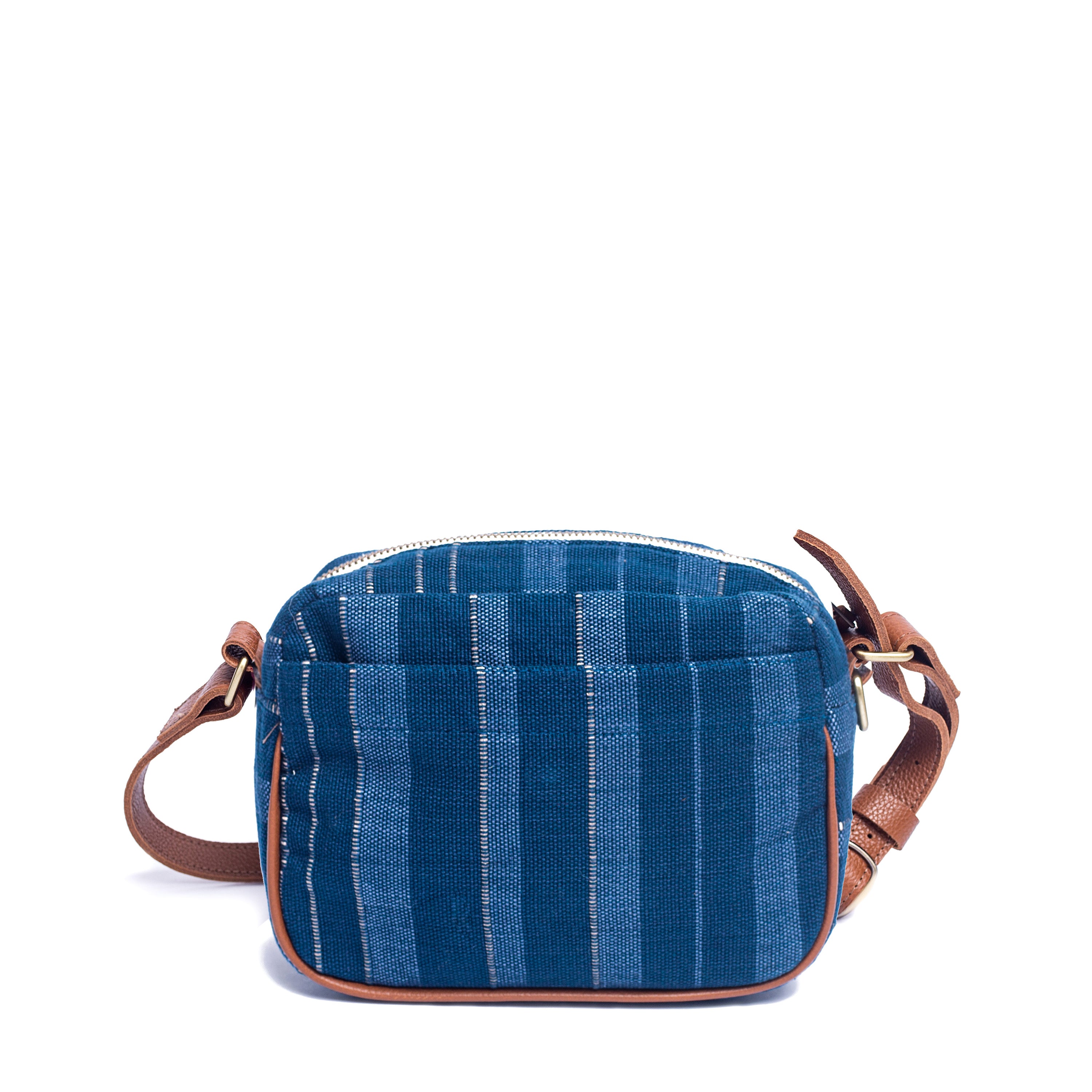 The backside of the hand woven artisan Juana Crossbody in Sky Haze pattern. It has leather vein detailing, a leather adjustable strap, a top that closes with a zipper, and a back pocket.