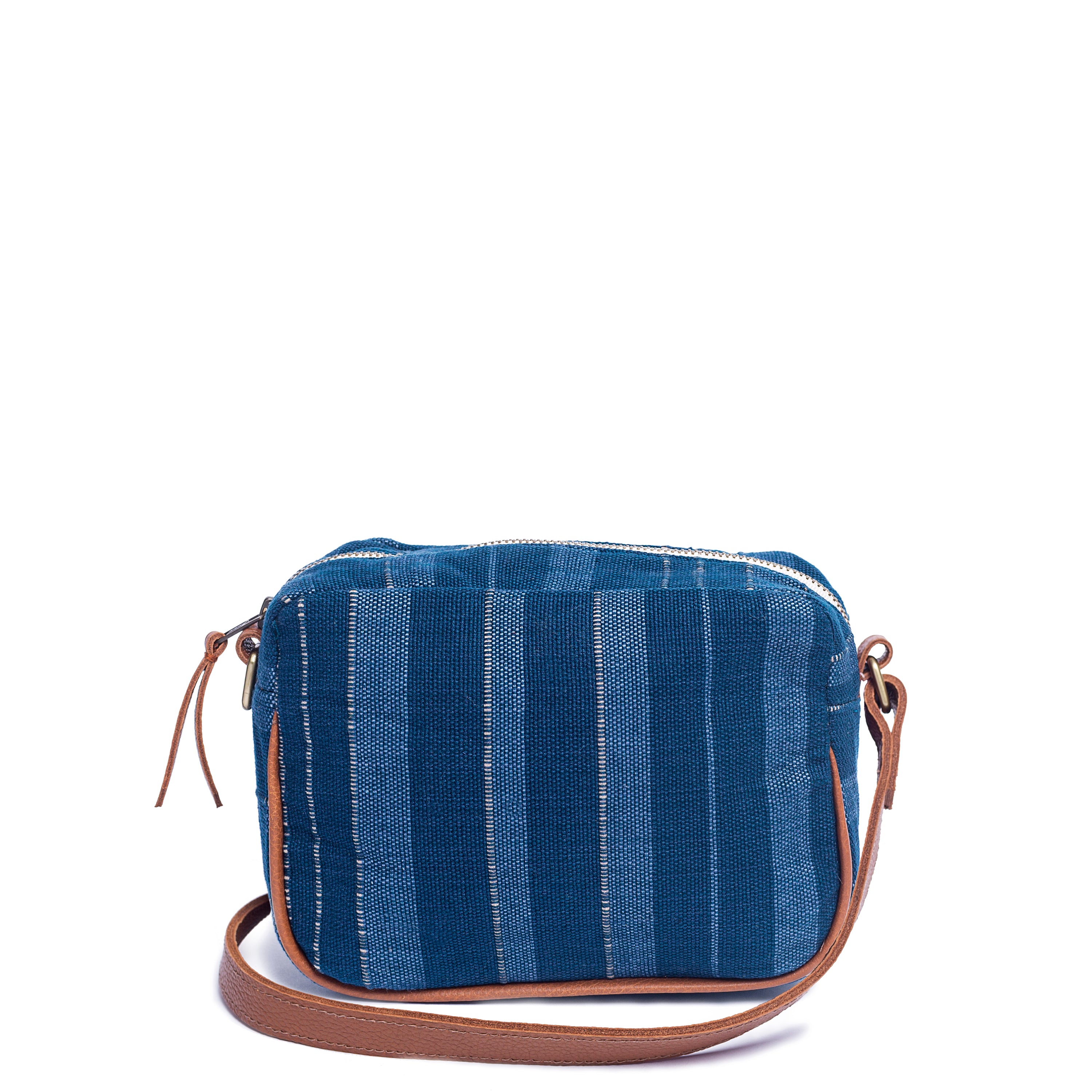 Juana Handwoven Crossbody Sky Haze. The Sky Haze pattern has vertical dark blue, lighter blue, and grey stripes. It has a leather vein detailing and leather strap.
