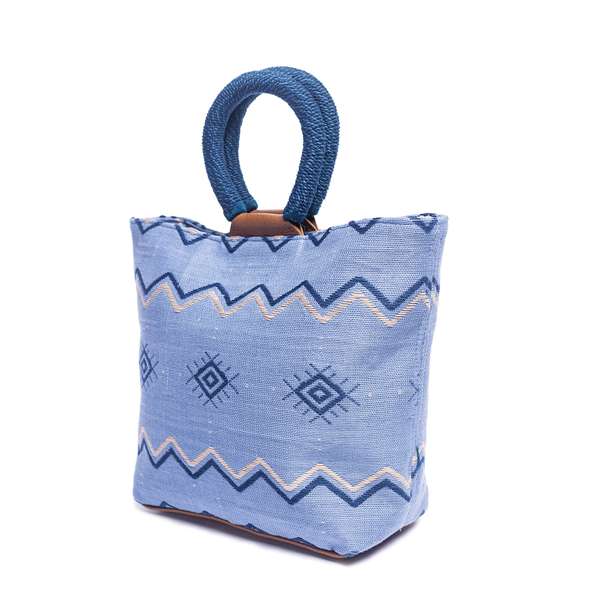 A side view of the hand woven artisan Dalila Midi Tote in Mountain Blue. The photo shows the tote without the leather strap.