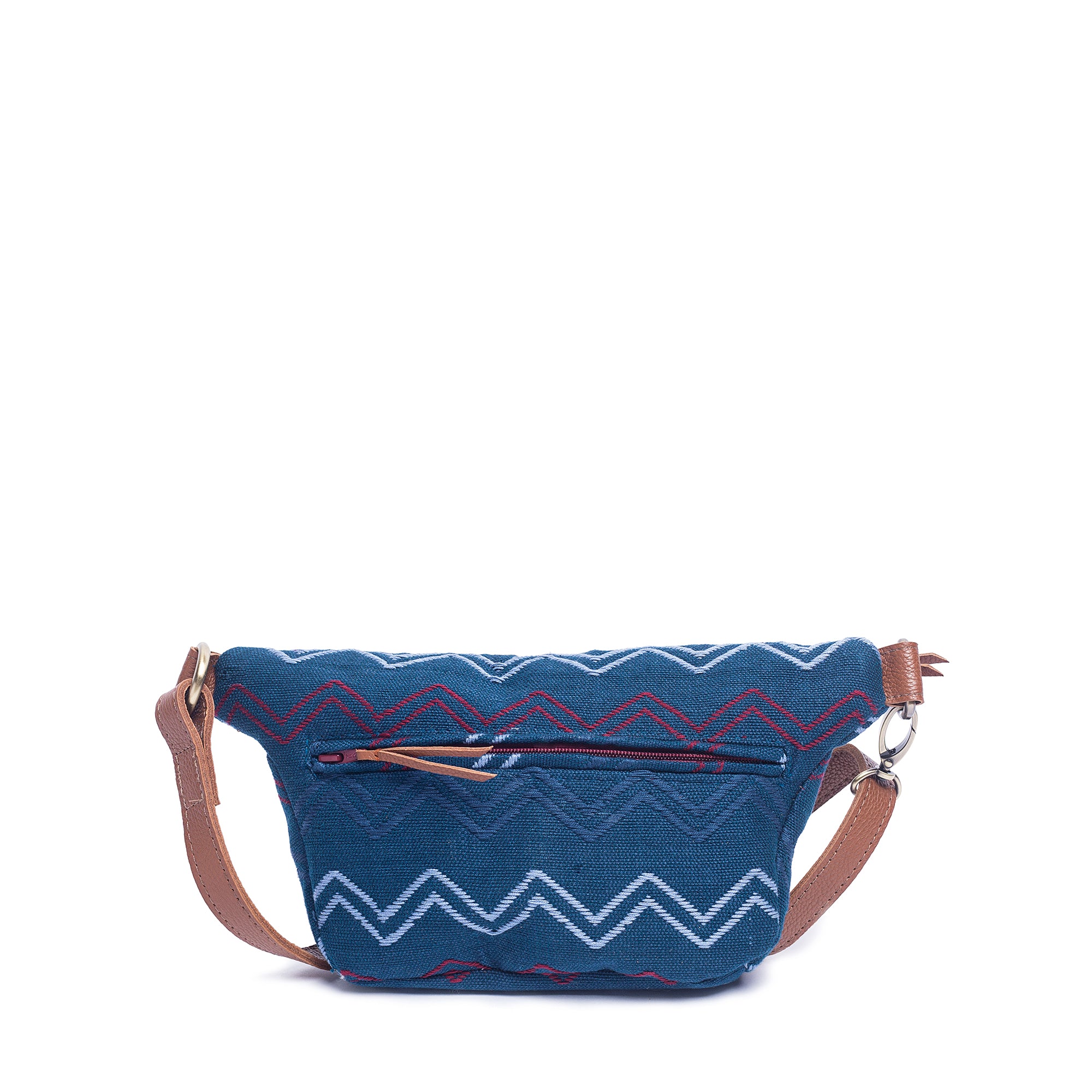 Back of the hand woven artisan Cruza Sling Belt Bag in Lake Ripple pattern. The fabric has a horizontal zigzag in light blue, dark blue, and red over a dark blue fabric. It has a leather adjustable strap, leather hem for the zipper, and leather zipper pull. The back also has a zippered pocket.