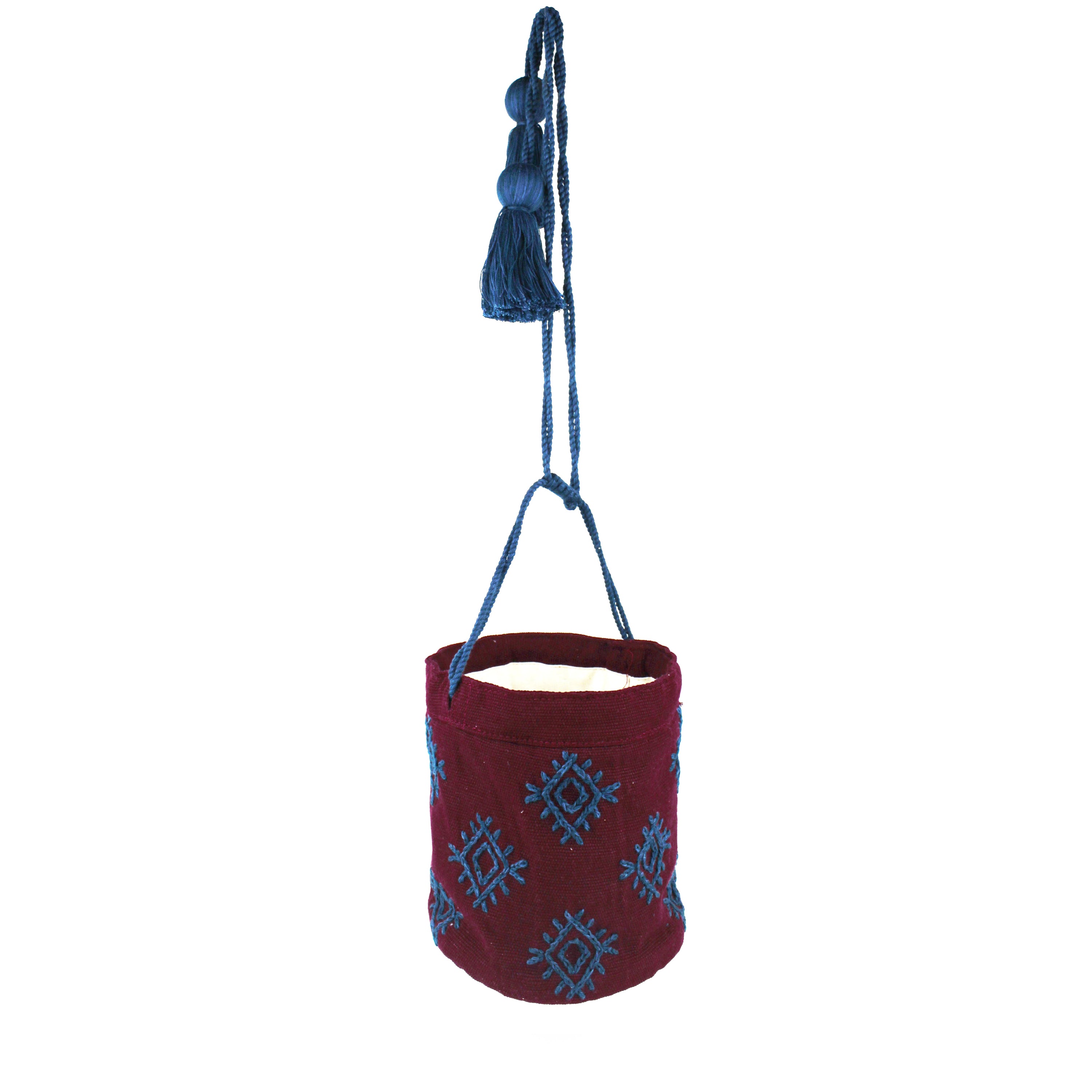 The hand woven artisan Hermelinda bag in Mountain Dusk. It is open and suspended by the blue drawstrings.