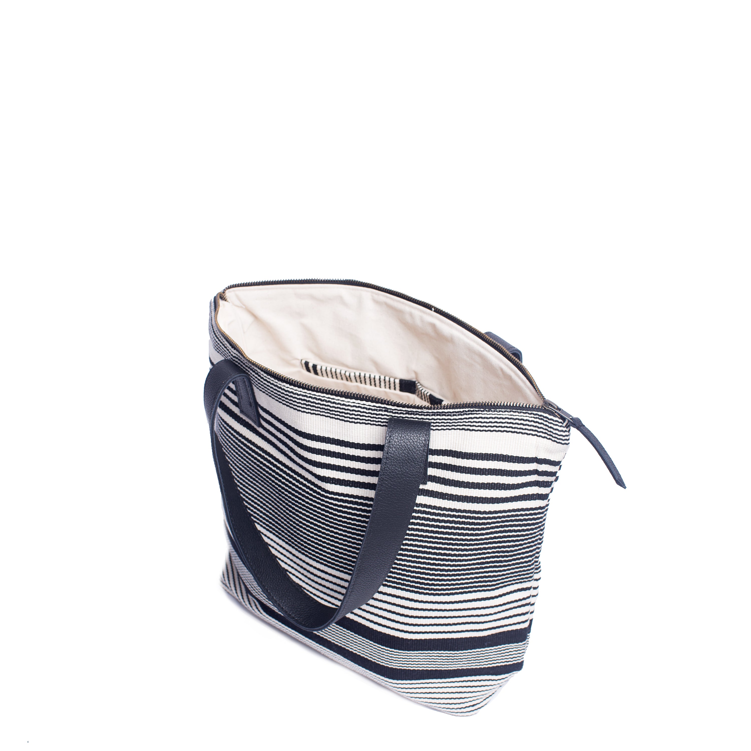 The hand woven artisan Angela Tote in Black and White Stripes is unzipped and open. The interior has a white lining.