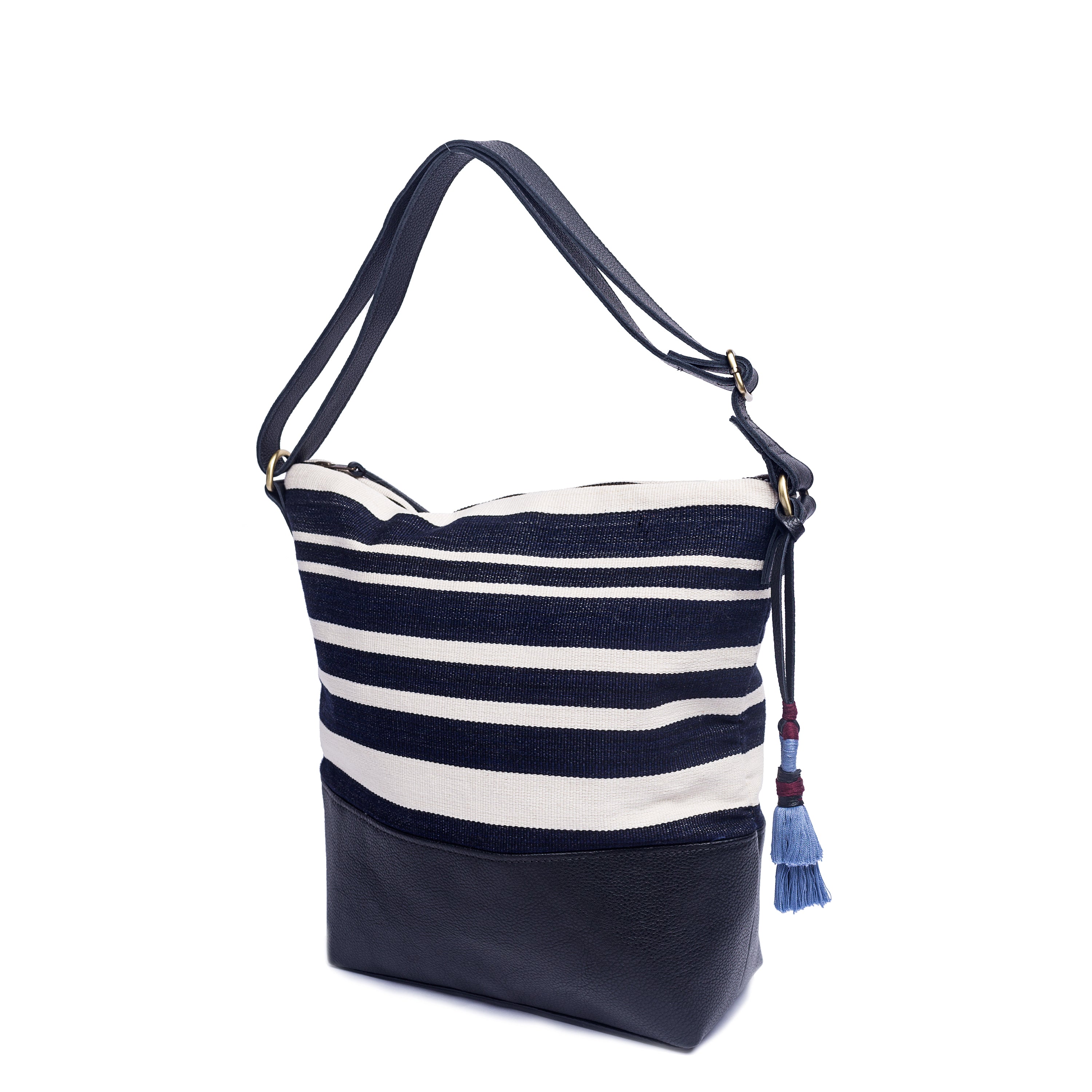 Hand Woven Artisan Lidia Hobo Shoulder Bag Midnight Black. The Midnight Black pattern has vertical navy blue and white stripes. It has a navy adjustable leather strap, a leather bottom lining, and a blue tassel.