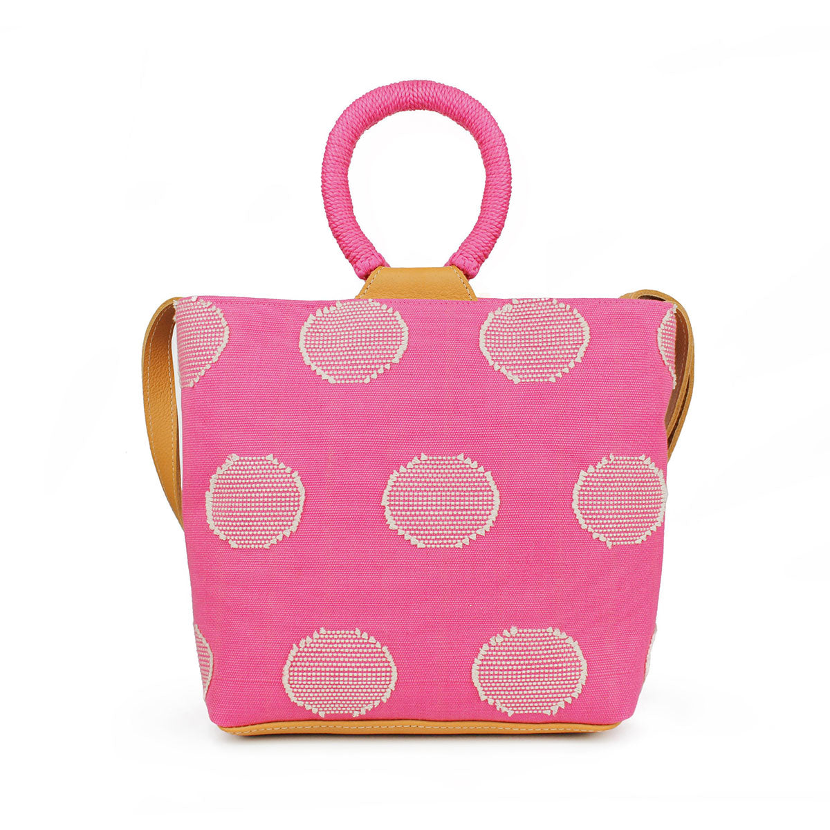 The hand woven artisan Dalila Midi Tote in Sunset Pink. It has rounded handles coiled in pink thread. The Sunset Pink pattern has white circles over a pink background.