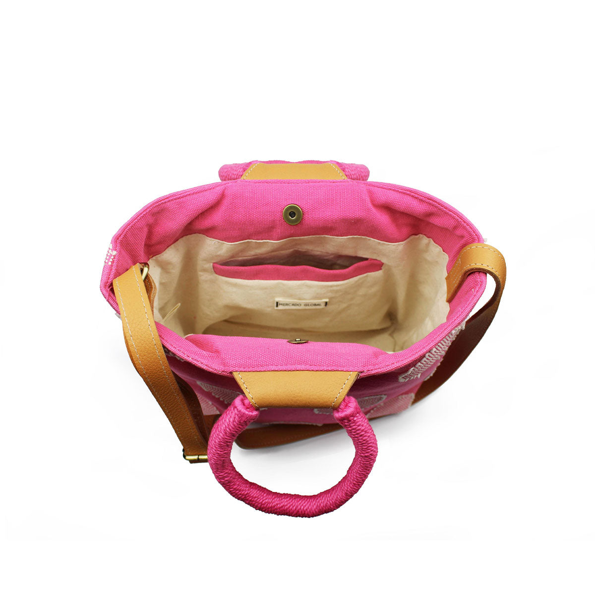 A top view of the interior of the hand woven artisan Dalila Midi Tote in Sunset Pink. It has a beige lining and an interior pocket with a pink hem. The bag closes with magnetic clasps.