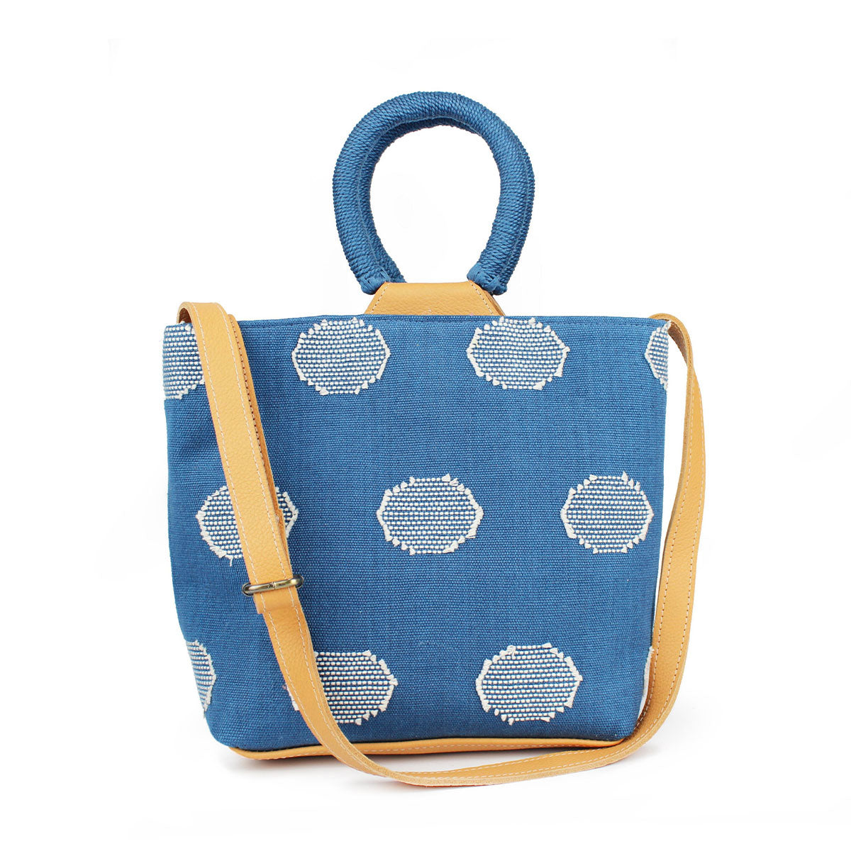 Front of the artisan Dalila Handwoven Tote in Ocean Blue. The tote has rounded handles coiled in blue thread. The Ocean Blue pattern has white circles over a blue background. It has a leather adjustable strap.