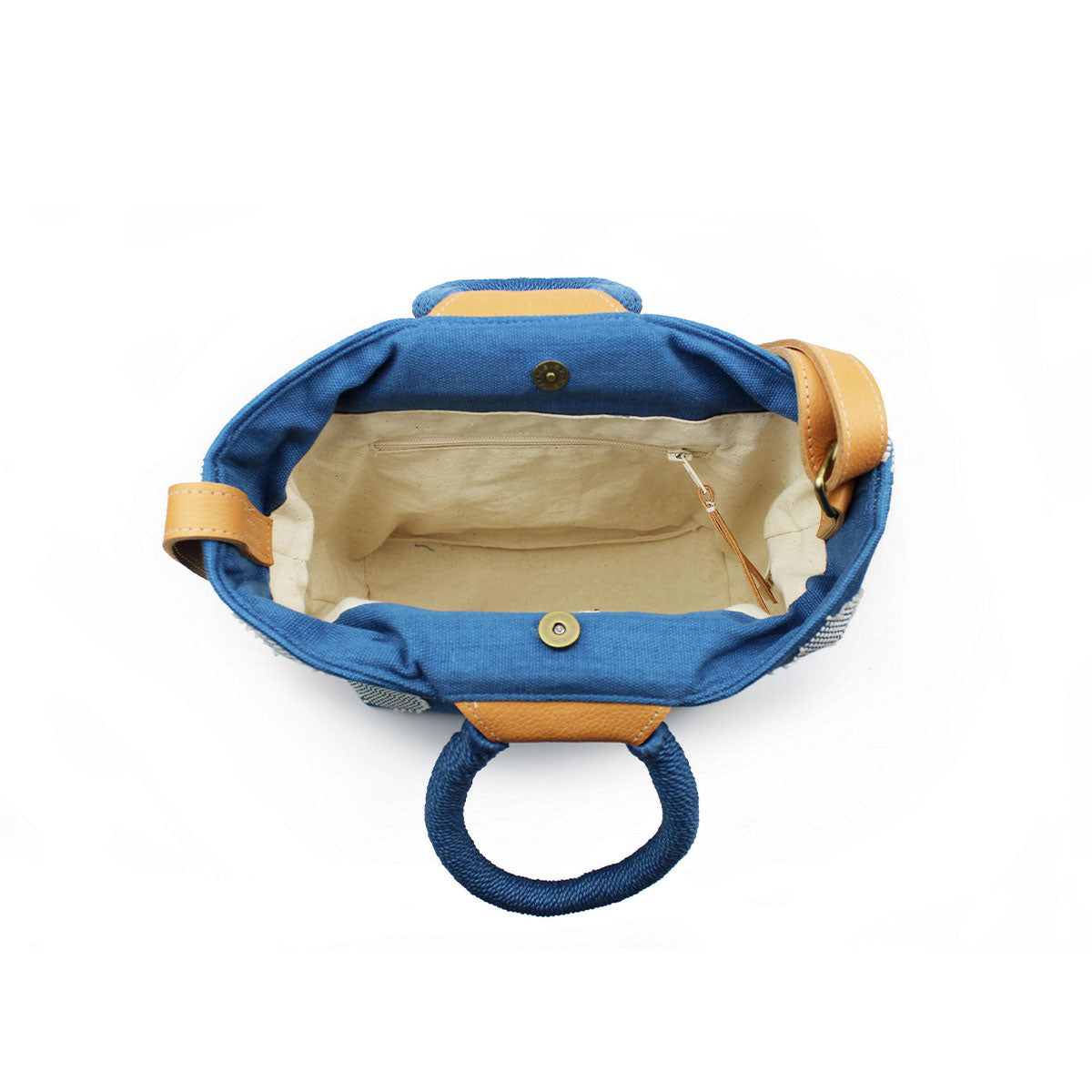 Another top view of the artisan hand woven Dalila Midi Tote in Ocean Blue. The side shows a pocket with a leather zipper pull. It has beige lining. The bag closes with magnetic clasps.