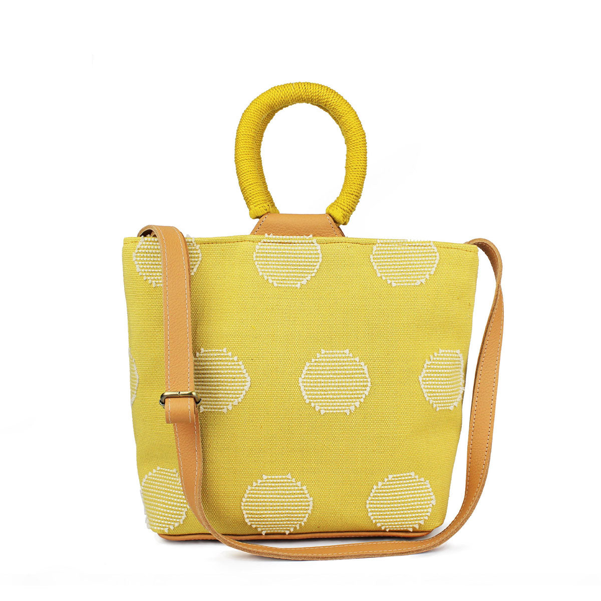Front of the artisan Dalila Handwoven Sunrise Yellow Midi Tote. The tote has a bucket shape with rounded handles coiled in yellow thread. The pattern has white circles over a lemon yellow background. It has an adjustable leather strap.