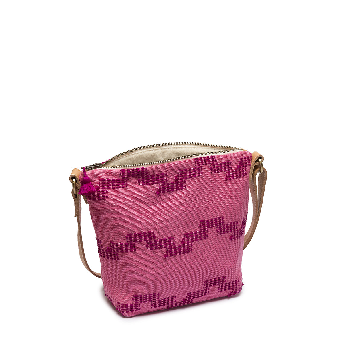 A side view of the hand woven artisan Mini Lidia Crossbody in Pitaya style. The zipper is open to reveal the interior with beige lining. 