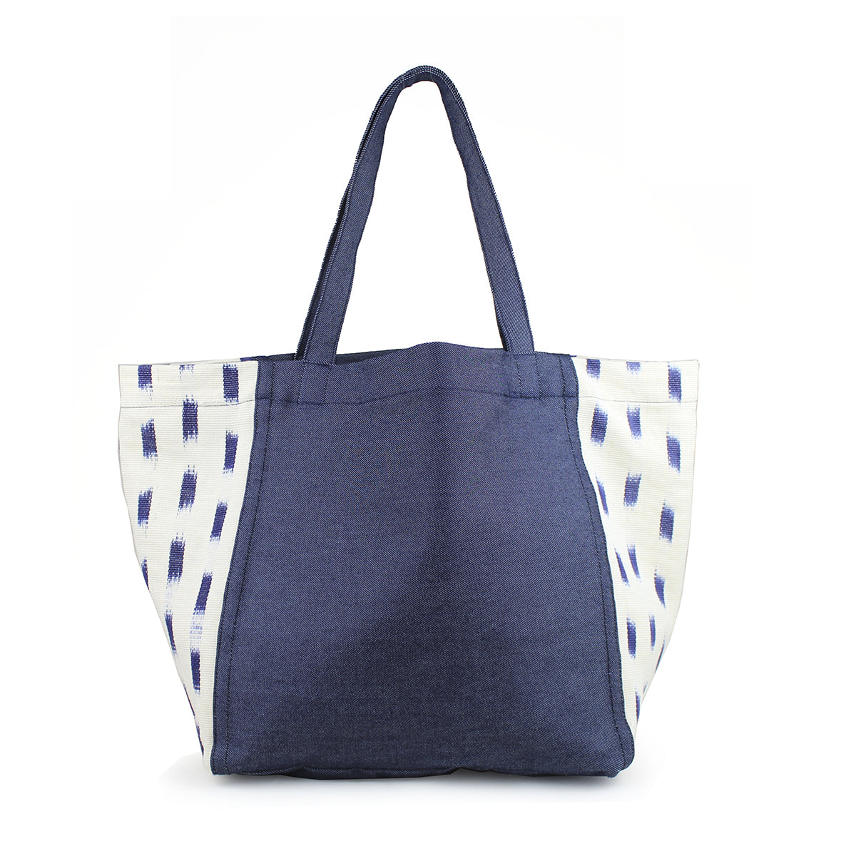 Blanca Artisan Handwoven Tote in Denim Jaspe. The tote has a dark denim wash. The sides have an abstract blue square pattern over a white background.