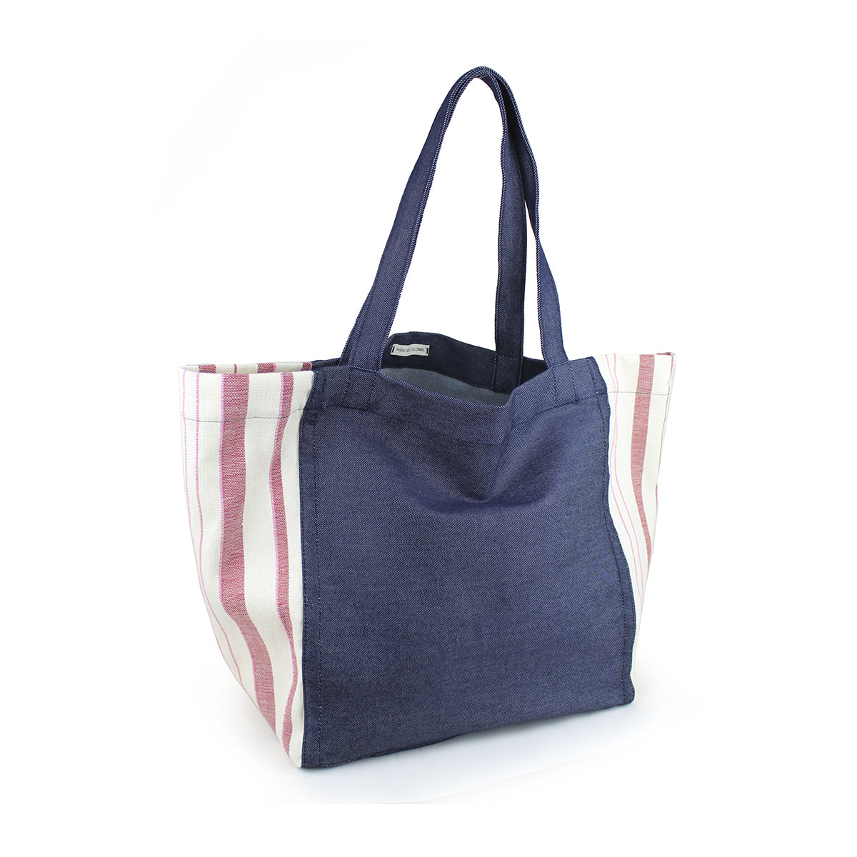 A left-sided angle of the hand woven artisan Blanca Tote in Denim Sunset pattern. The Tote has a dark wash denim center and handles. The sides have a triangle finish in a light red and white vertical striped fabric.