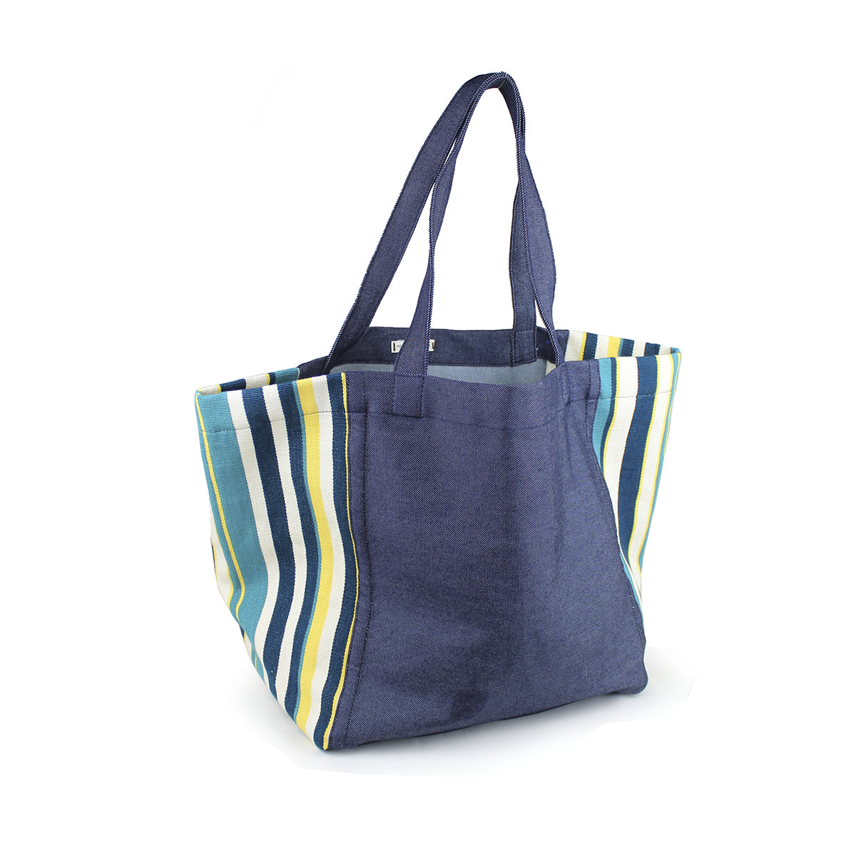 A left-sided angle of the hand woven artisan Blanca Tote in Pacific pattern.  The bag has a dark wash denim center and handles. The ends of the bags have a triangle finish in blue and yellow vertical stripes. 