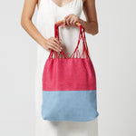 A model hods the Apolonia Tote in Raspberry.