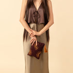 A model holds the hand woven artisan Raquel Clutch in Season Sparkle.