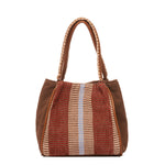 Hand woven artisan Flora Petite Tote in Chestnut shown at the back. The sides of the bag are in solid brown colors. The leather handles have white embroidered detailing. The Chestnut pattern has thick brown and tan stripes.