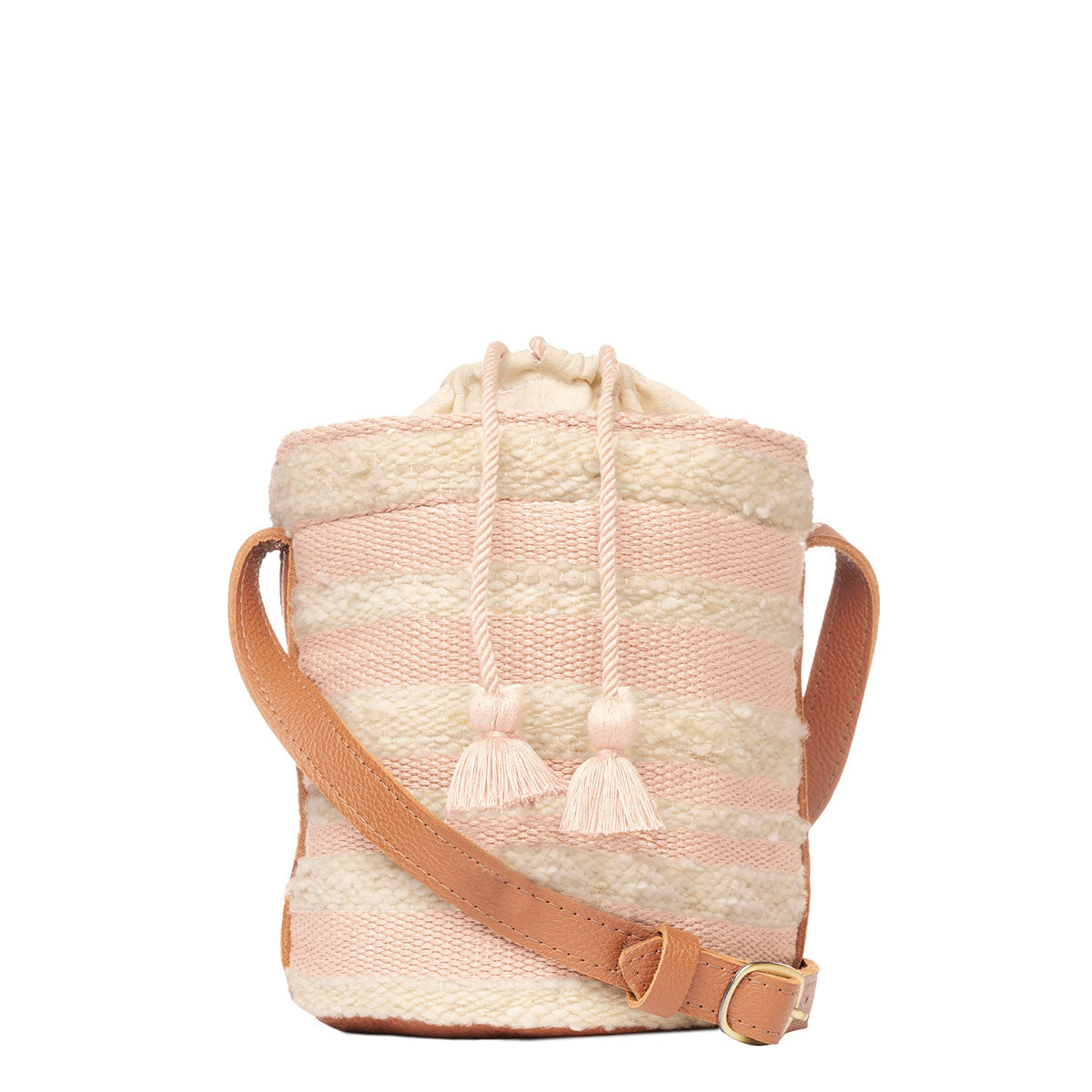 Front of artisan hand woven Betty Cylinder Crossbody in Snow. It has an adjustable leather strap. It has horizontal pale pink and beige stripes and pale pink tassels.