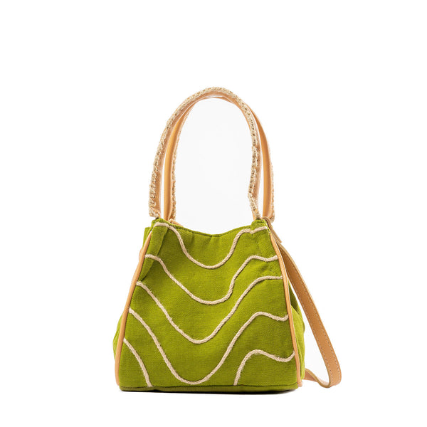 Front of the hand woven artisan Flora Petite Crossbody in Turf Moss. The Turf Moss pattern has wavy horizontal lines over a green background. It has embroidered detailing on the leather handles and a detachable leather strap.