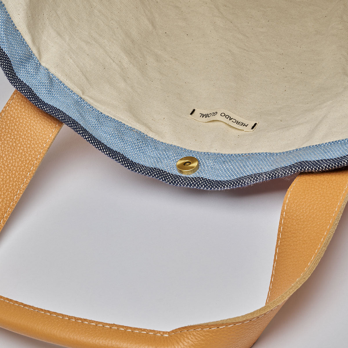 Interior view of the Magali Tote in Blue Canyon. It has magnetic clasps and beige cotton lining.