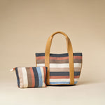 Magali Tote and Cristina Pouch in Blue Canyon placed together over a tan background.