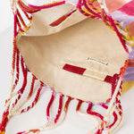 The interior of the hand woven artisan Apolonia Tote in Raspberry Paleta. The interior has a beige solid color lining and a red striped hem.