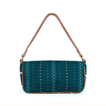 Back view of the Olivia Artisan Handwoven Deep Forest Shoulder Bag. It has a deep turquoise and white geometric pattern. It has a leather strap and leather piping. The bag has a short and long width shape.